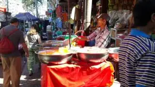 Drink seller plays nice music on his buckets. Colorful Market scene Yangon, Myanmar