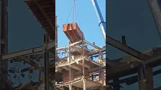 Digger working in the air suspended by a crane in Brussels