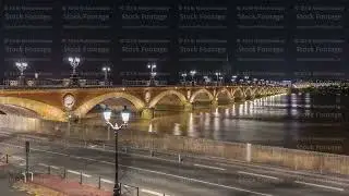Pont de Pierre stone bridge with Porte de Bourgogne night timelapse in Bordeaux, France.