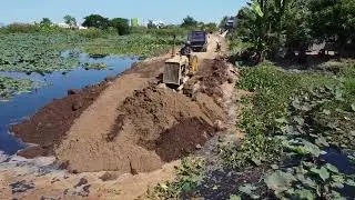 Powerful Bulldozer Pushing Dirt into Water for Road Project