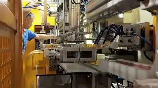 Look,Super MKB-5LD Hybrid blow molding machine is making 2 layers Mistine sunscreen bottle.
