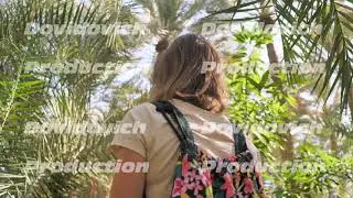 A girl walks through the palm jungle.