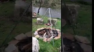 Cook Meat on a Tripod Grill Over Open Camp Fire