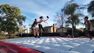 kids playing football on giant 70 foot x 30 foot superior inflatables bounce pad