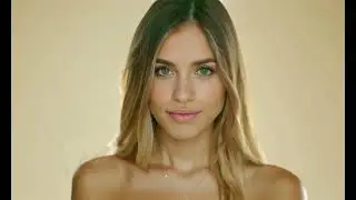 Young blonde model posing and looking at camera on a beige background