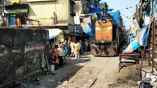 स्लम में बने फाटक से हॉर्न बजाते हुए निकला रतलाम का डीजल इंजन।