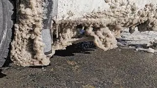 large ice formation around wheel of car under direct sun light