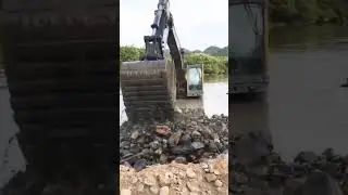 Excavator clearing riverbed stones process