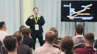Man speaking at conference with audience seated facing him