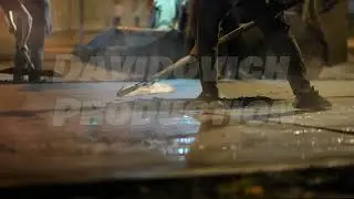 Construction workers repaving road with hot asphalt in city street at night
