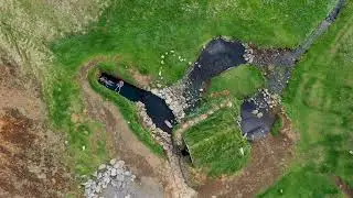 Hrunalaug hot spring pool. 4k Aerial view by drone. Fludir, Iceland