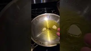 Pasta aglio olio in a stainless steel pan