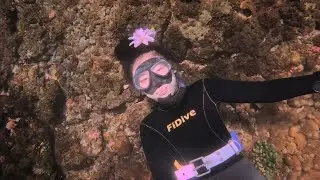 Freediving Girl Glides Over Coral Rocks 