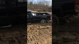 Cat d4 bulldozer pulling truck out of mud