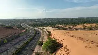 15995520 hd 1280 720 24fps  A highway runs through a desert with trees and sand dunes