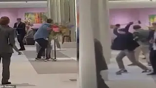 Brazen gun-wielding thieves use a sledgehammer to smash a display case before making off with 'items