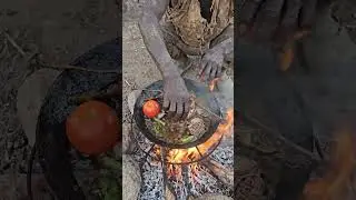 Hadzabe eating wild food during a quiet camp moment.#Hadzabe #PrimitiveCooking #WildFood #shortsfeed
