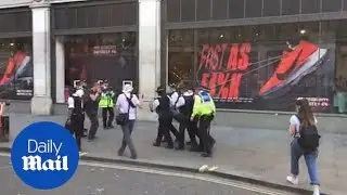 Activist moved away by police at Oxford Circus protest