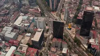 High angle aerial view of heavy traffic in streets of downtown. Drone flying forwards and camera