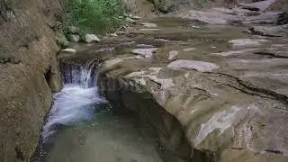 Stock Video - Water flowing over rock into pool in Orderville Canyon