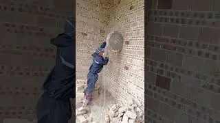 Professional Worker Cutting a Perfect Circular Opening in a Brick Wall Using Wall Saw