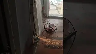 Satisfaisant un travailleur avec une disqueuse coupe un cadre en acier, regardez les &eacute;tincelles fer