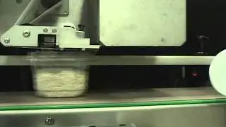 Label-aire label applicator applying labels to top of products