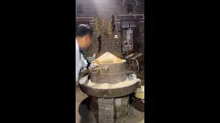 A stone mill for grinding flour, a traditional Chinese food processing machine.