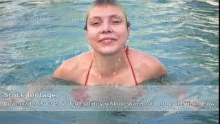 Young woman in red bikini emerging from the water