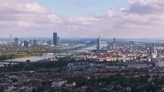 Aerial view of Vienna, Austria featuring the Danube River and the dc tower. Clouds are passing