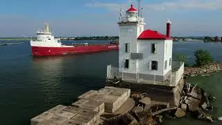 53 year old Great Lakes freighter Frontenac sails from Fairport Harbor by west breakwater lighthouse