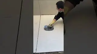 The process of installing large white ceramic tiles on the building floor is easy, fast and neat