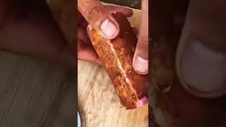 Knife slices seasoned sausage&mdash;pink center revealed beneath spiced crust and wooden board