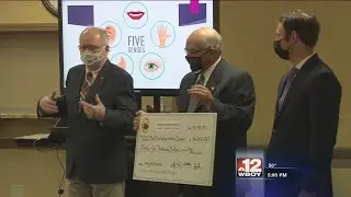Delegates present check to Disability Action Center