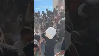 Palestinians crowd onto aid trucks moving through Gaza
