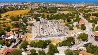 Didim, Turkey. Drone flight from Apollo Temple entrance to general view showing Didim town, field...