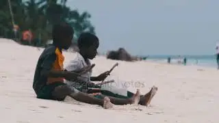 Two Local African Boys Sit on Beach and Play Improvised Bottle Drums, Zanzibar &mdash; Royalty-free