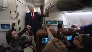 Дональд Трамп общается с журналистами на борту президентского самолета Air Force One перед призем...