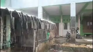 Heavy rain is pouring down on the roofs of houses in a village; the rain is perfect for therapy. 