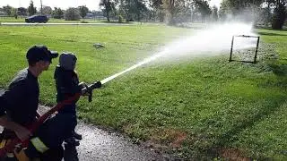 Using the firehose at Fire Safety Awareness event in town.