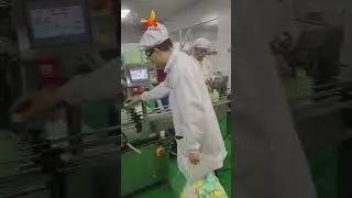 Photo r&eacute;elle d'une machine industrielle automatique de remplissage et de capsulage lin&eacute;aire.