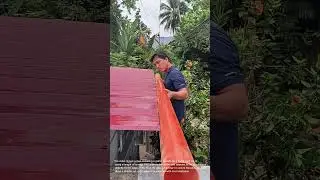 DIY Gutter Installation: Man Attaches PVC Pipe to Metal Roof