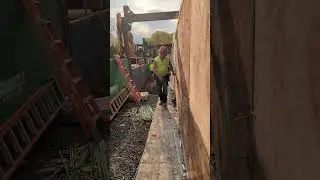 Taking form liner off a concrete wall.