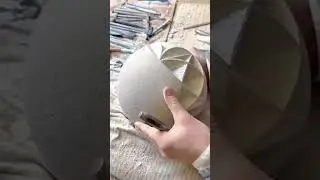 Skillfully carving intricate geometric patterns onto spherical stone
