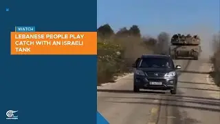 Lebanese people play catch with an Israeli tank