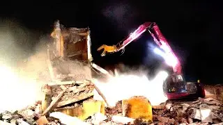KOBELCO SK 135 SR excavator demolishing construction site, truck in operation