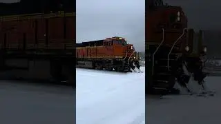 BNSF ET44C4 3954 and BNSF ES44DC 7621 leading an empty grain train through the snow.