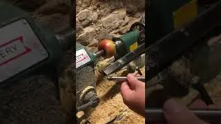 Man peels an apple on his lathe.