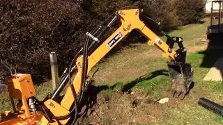 ATBH7 towable backhoe digging up root balls from shrubs.