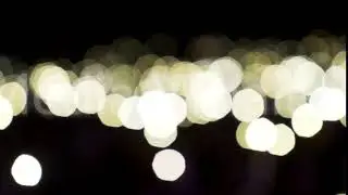 Defocused beige lights moving slowly on black background. Action. Flowing bokeh bright circles of
